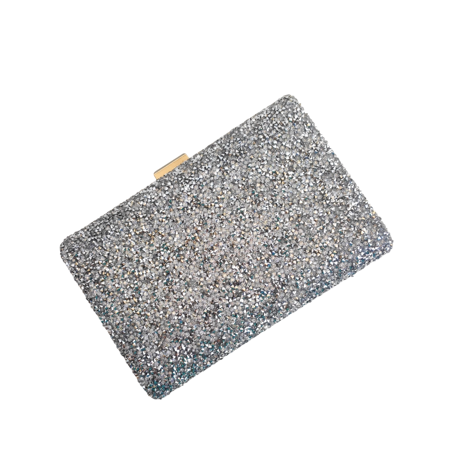 Detalhe do acabamento de pedraria em bolsa clutch prata brilhante