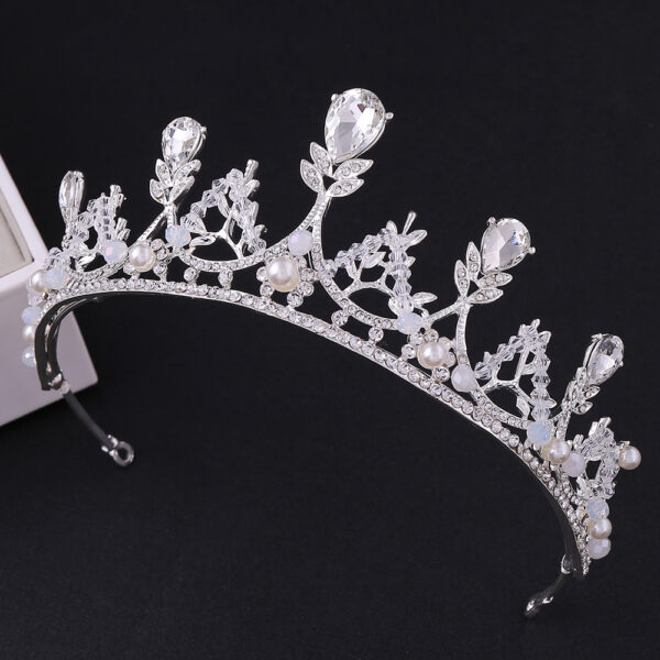 Coroa prateada de luxo para noiva ou debutante, vista de frente em fundo preto. A peça possui cristais em formato de gota e redondos, intercalados com pérolas brancas delicadas. Altura de 5,5cm.